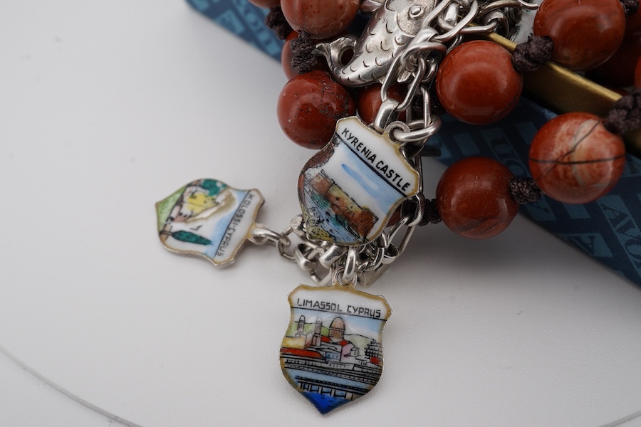 A mixed group of silver jewellery, including two charm bracelets, an Art Nouveau-style pendant; a pocket watch on chain; a pair of moonstone earrings; an onyx and marcasite pendant; a cross pendant; a carnelian pendant;